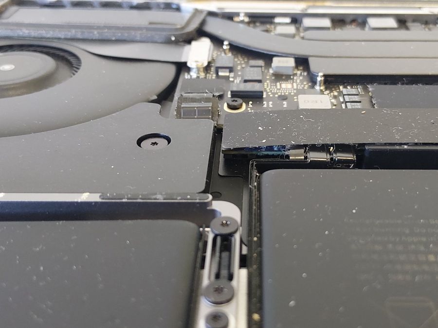 Dust and lint inside a MacBook Pro around the fan and battery – MacBook overheating fix, Christchurch